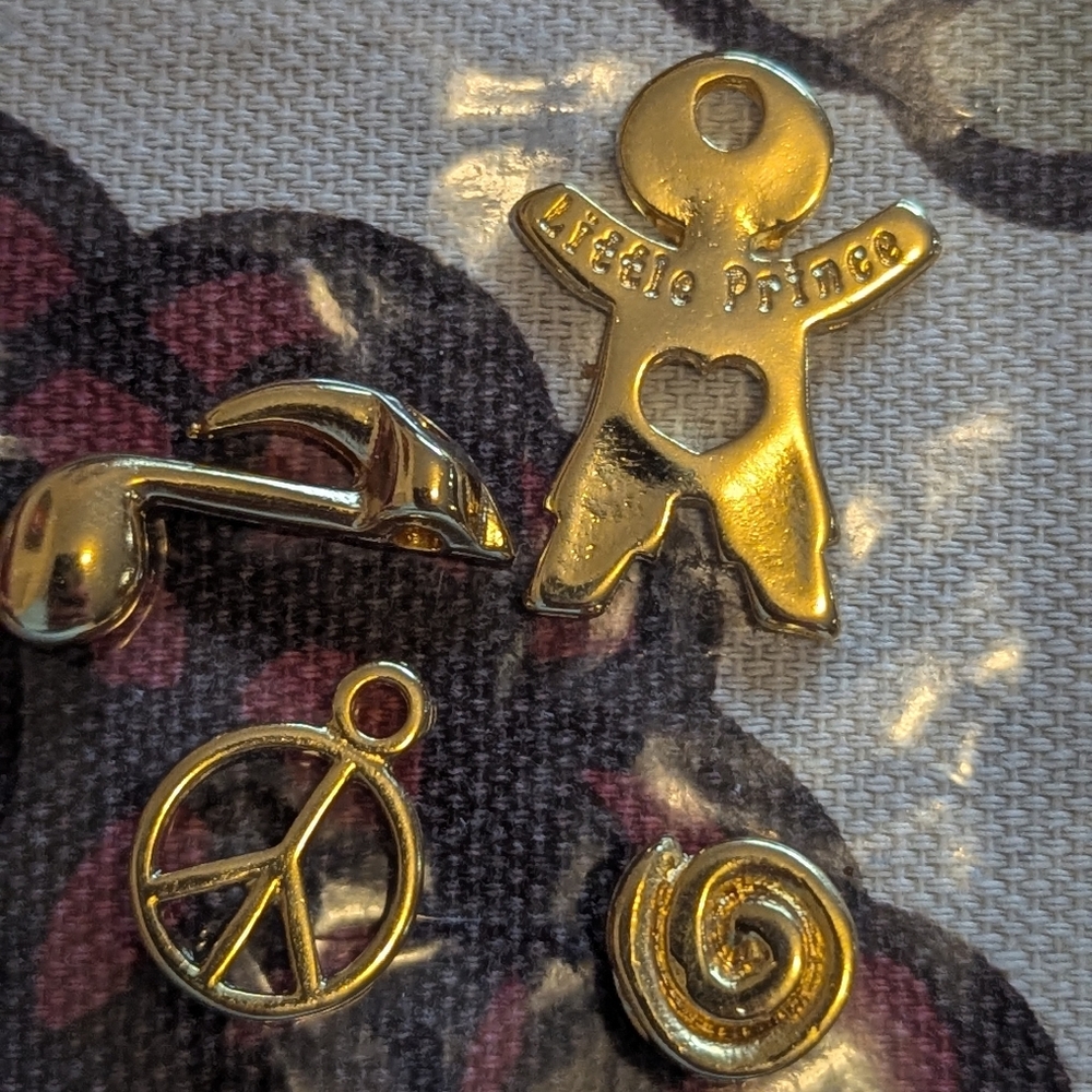 Four gold necklace charms. Peace, music note, little price, and swirl. Charms!